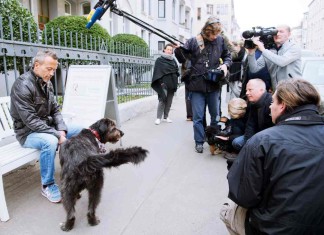 Mischlingshund Toby und sein Besitzer (l) warten am 13.04.2016 vor ihrem Wohnhaus in Hannover